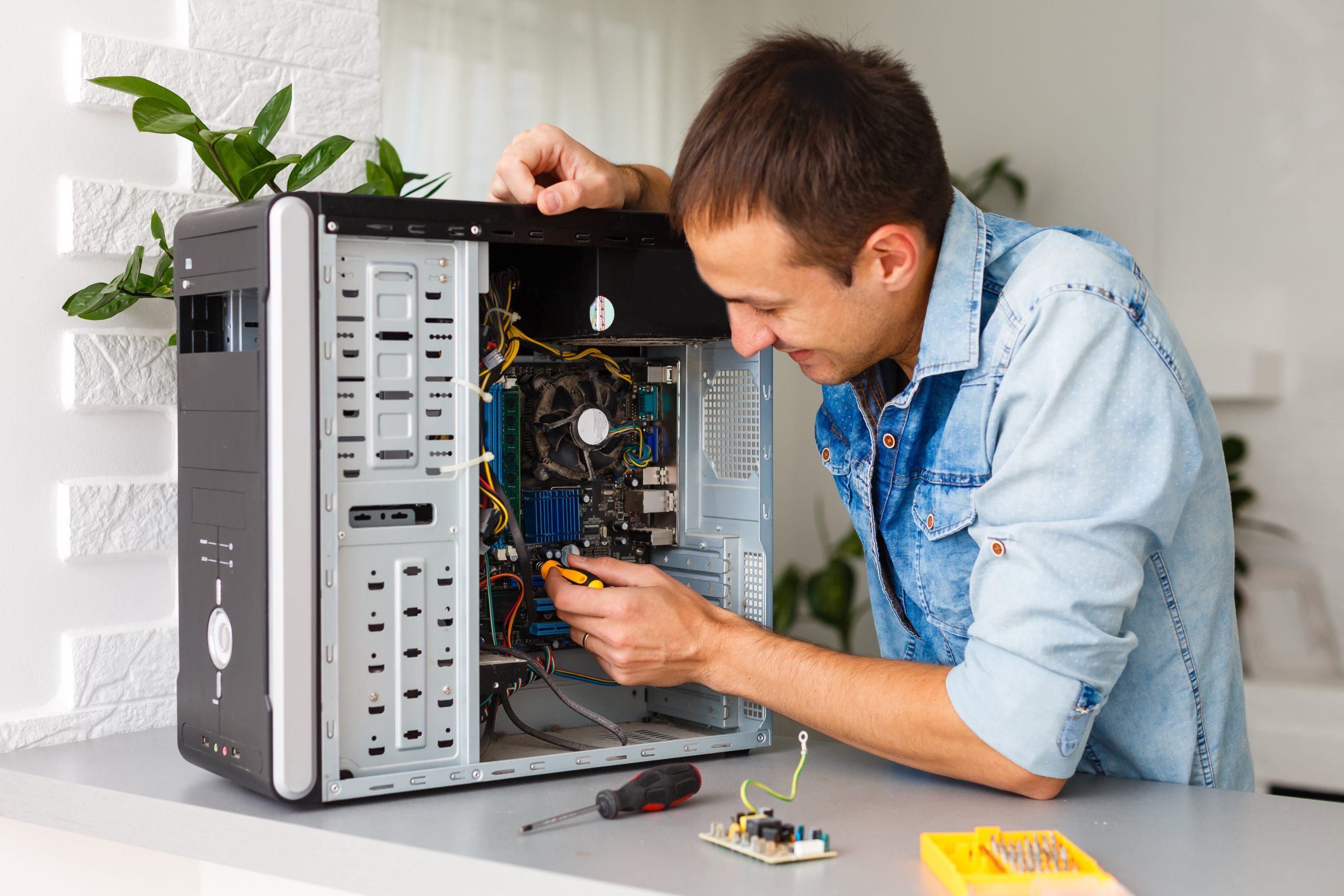 Technician repairing a desktop computer in an office setting.